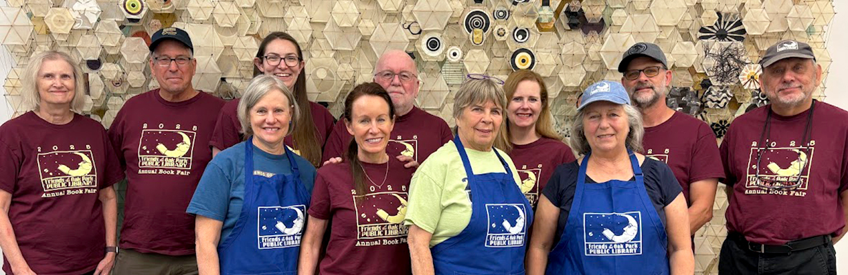 A group of people wearing Friends of the Oak Park Public Library t-shirts posing in the Main Library