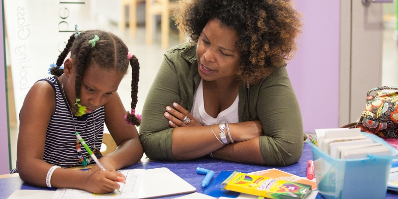 Adult helping child with homework.