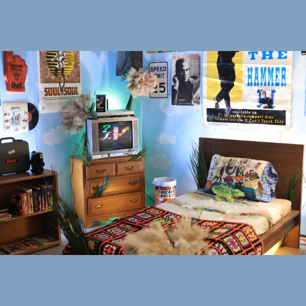 an recreated childhood bedroom with a tv and posters in the background